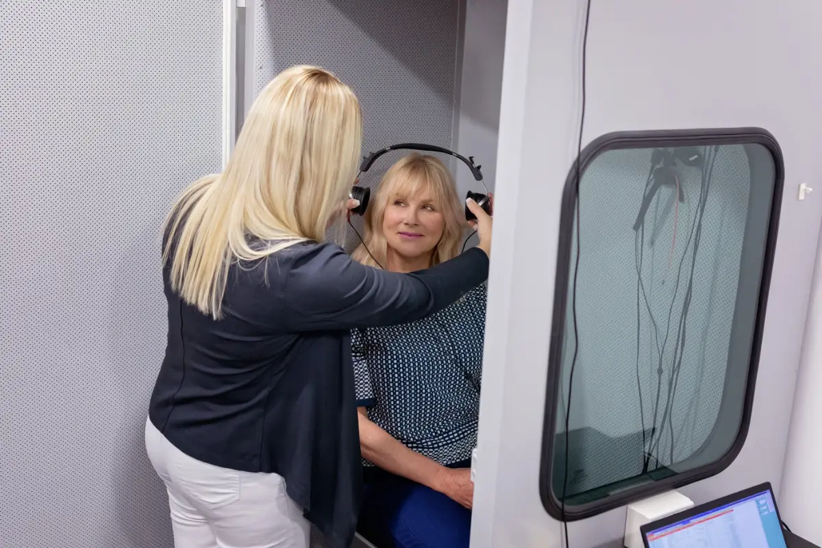 Audiologist with client for hearing assessment