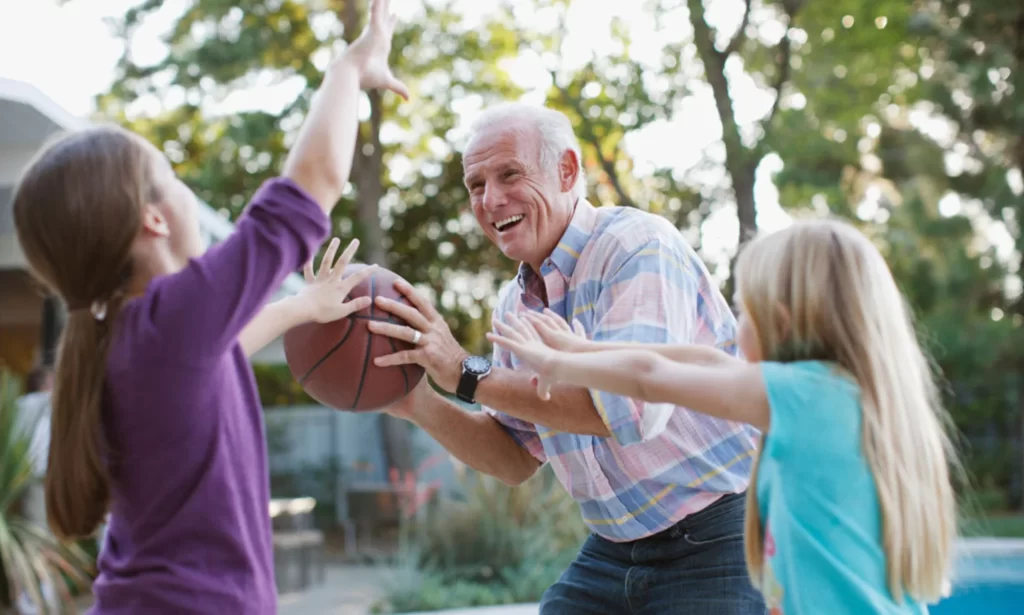 grandfather playing basketball with grandkids