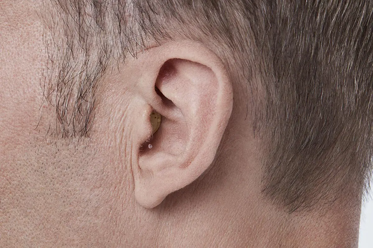 invisible hearing aid in ear of man
