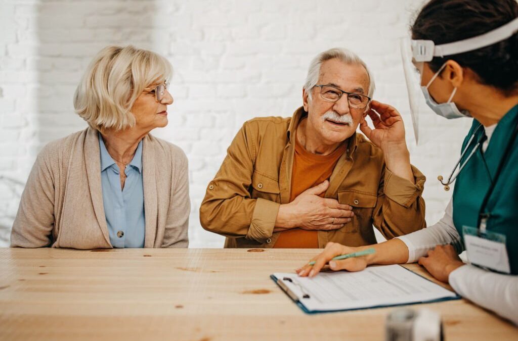 Doctor consulting senior couple regarding hearing loss solution