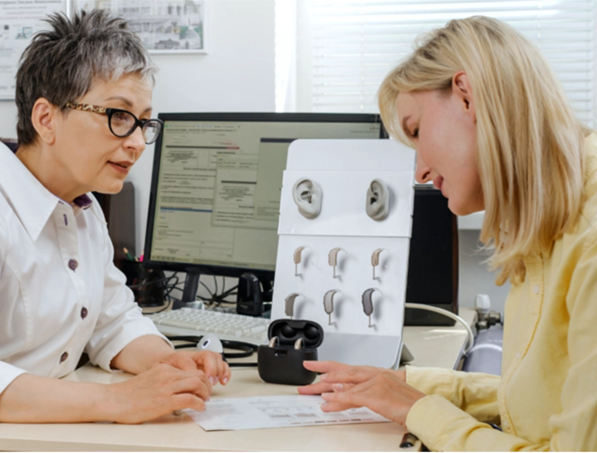 Audiologist with client asking about hearing aid pricing