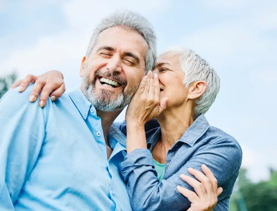 Woman whispering to partner -Celebrating World Hearing Day and Hearing Awareness Week 2025